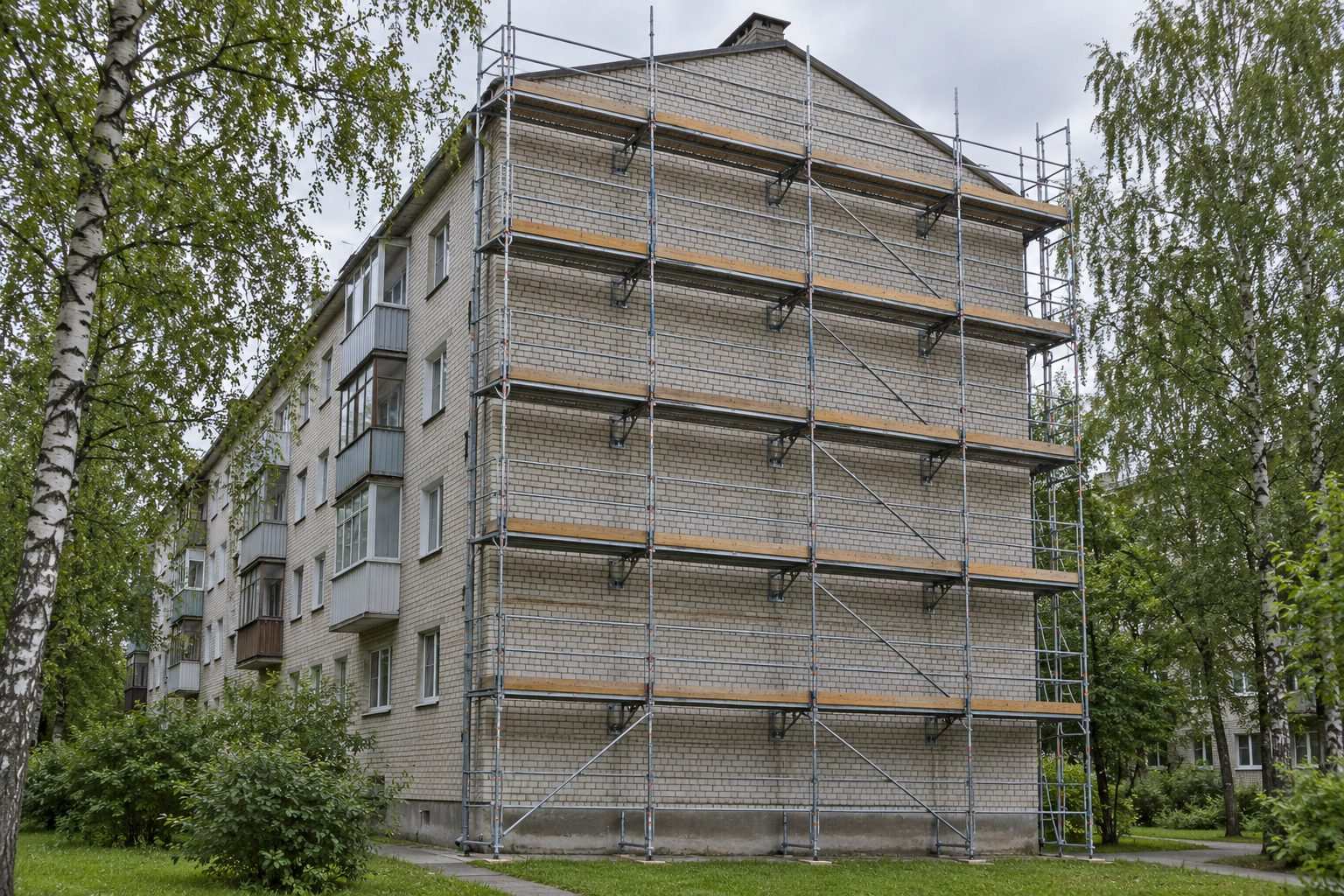 Fasādes sastatnes visā piecstāvu nama gala sienā
